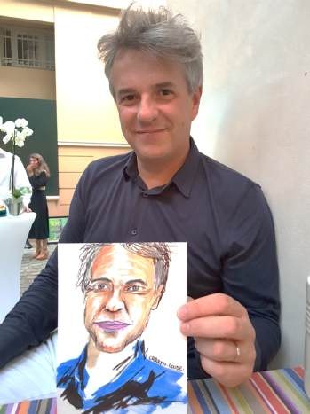 Un participant tient son portrait dessiné